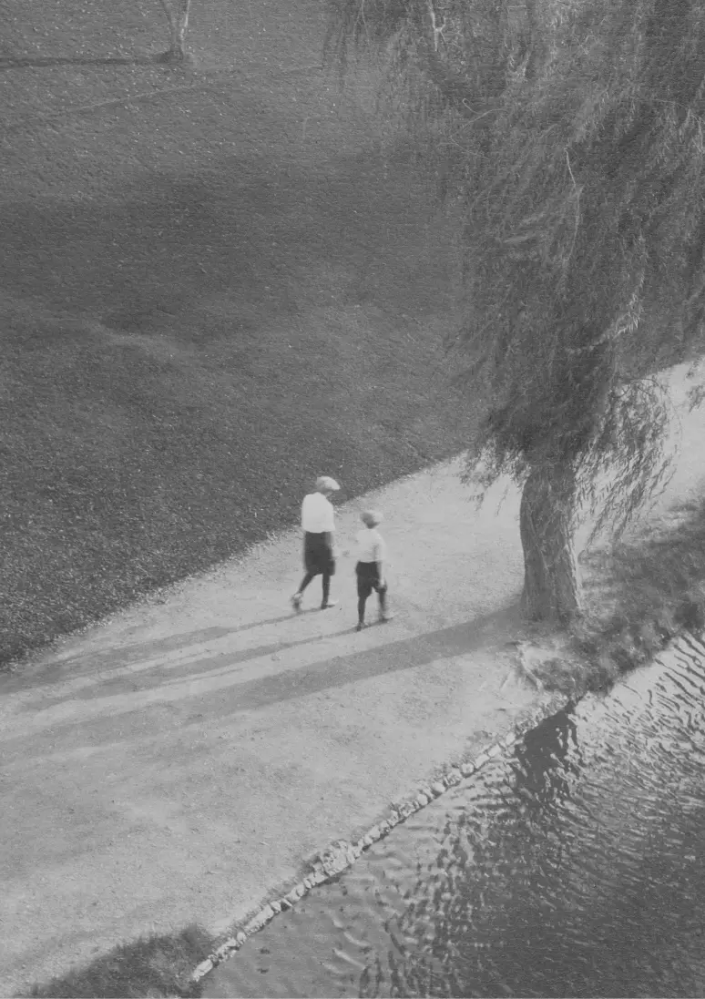 Foto en blanco y negro enfocando a una mujer y un niño desde lejos.